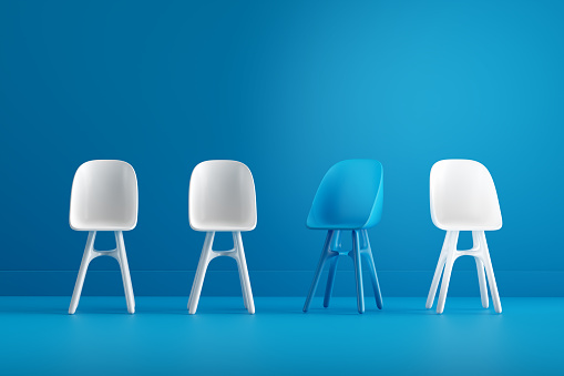 Difference, leadership, career occupation. Individuality and innovation. Vacant job position. Modern blue chair standing out from the blue chairs in an interior blue room. 3D Render.