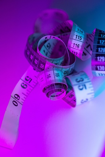 Close-up of a  measuring tape on a vibrant multi-colored background