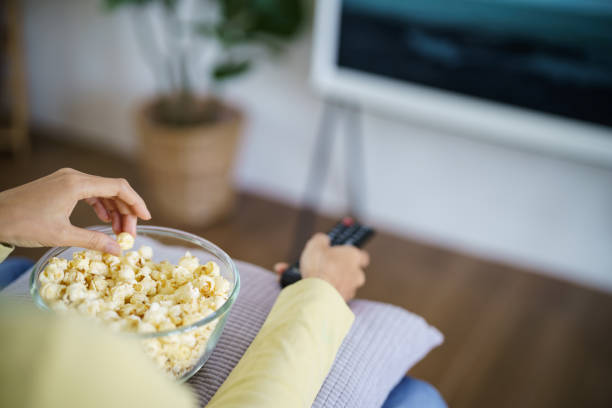 istock Asian woman Watching smart TV and using remote controller Hand holding television audio remote control at home with the remote control television 1488163802