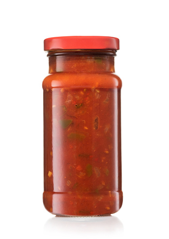 Glass jar with taco nachos salsa hot dip sauce on white.