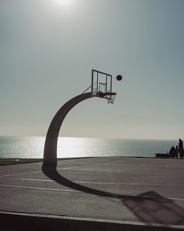 a basketball court at the edge of a cliff near the pacific ocean