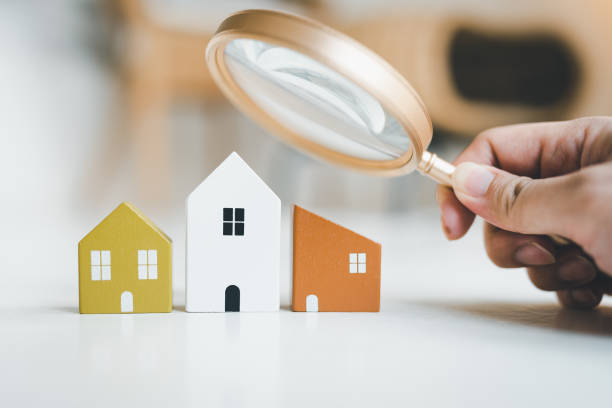 Magnifying glass and house model, house selection, real estate concept. stock photo