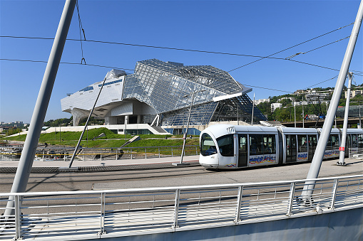 Lyon, France-05 03 2023: Tramway passing on a bridge over the Rhône river in front of the Confluence museum in Lyon, France.