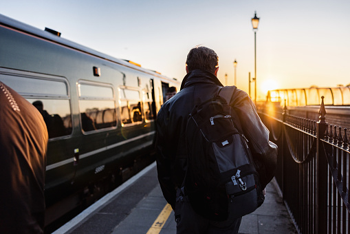 Mature Man Walking To And Entering A Train