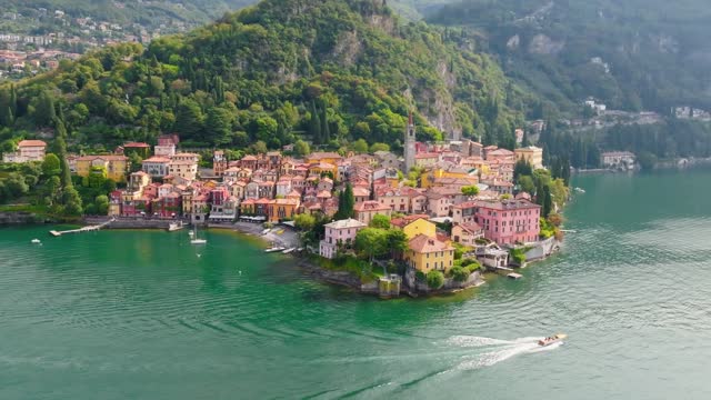 Aerial view of Varenna, Lake Como, Italy. Flying over orange roofs of old town with the church of San Giorgio in the central square