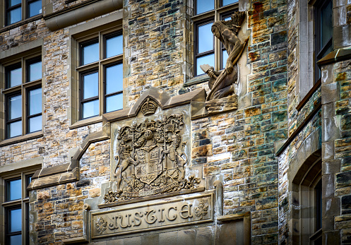 Facade of the historic Justice Building, Parliament Hill. The Canadian coat-of-arms with the word \