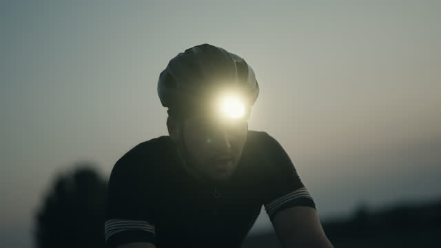 Close-up of road Cyclist Calmly Riding at Dusk and Breathing Deeply