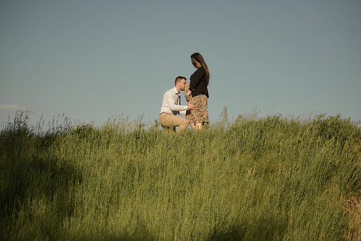 A young expecting couple enjoying together in the nature