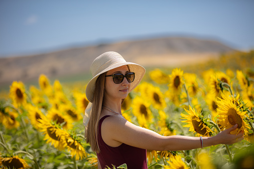 Beautiful blonde woman in sunflower field.