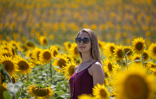 Beautiful blonde woman in sunflower field.