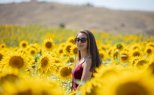 Beautiful blonde woman in sunflower field.