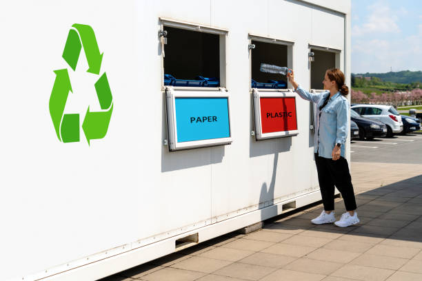 istock Separate waste collection station on street and person throwing plastic trash in garbage bin. 1488195836