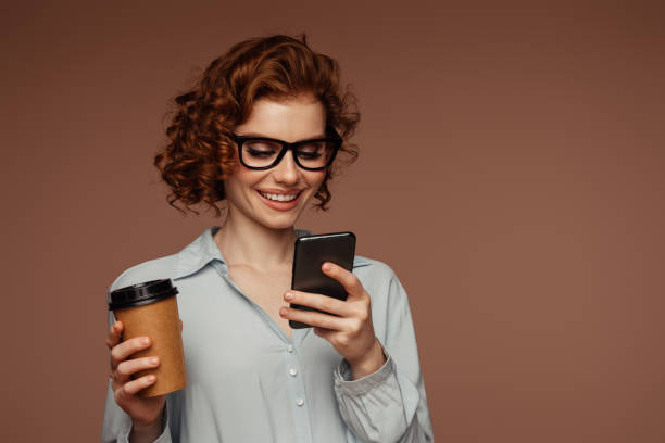 istock Beautiful emotional woman using phone and drinking coffee 1488199966