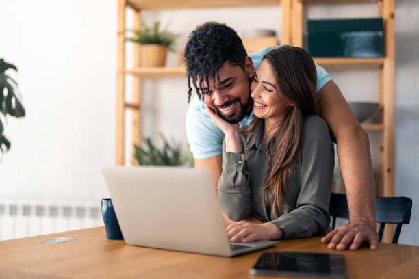 istock Young smiling couple in love working together on laptop computer 1488202039