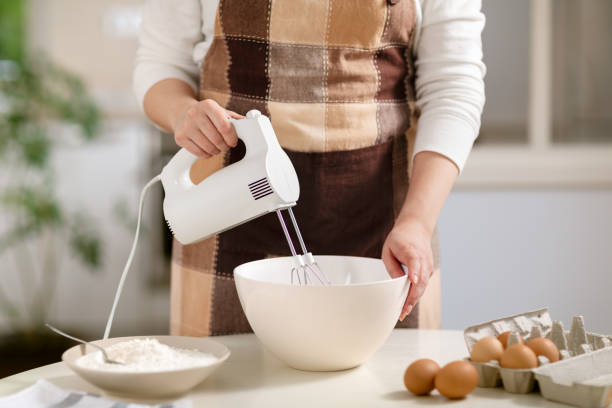 istock Young woman using electric mixer 1488205970