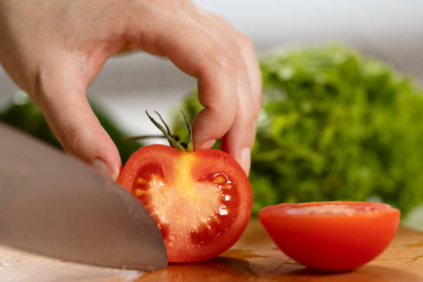 istock Close-up of hand cutting tomato 1488206035