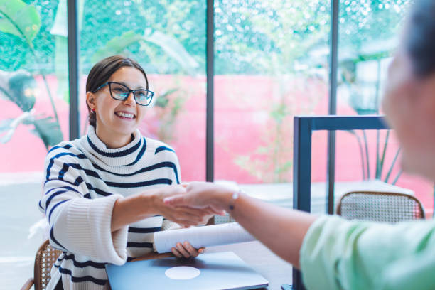 dos mujeres se saludan con un apretón de manos después de una entrevista de trabajo - opportunity handshake job business fotografías e imágenes de stock