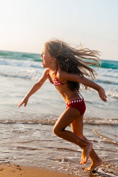 istock Playful girl running on the beach 1488208418