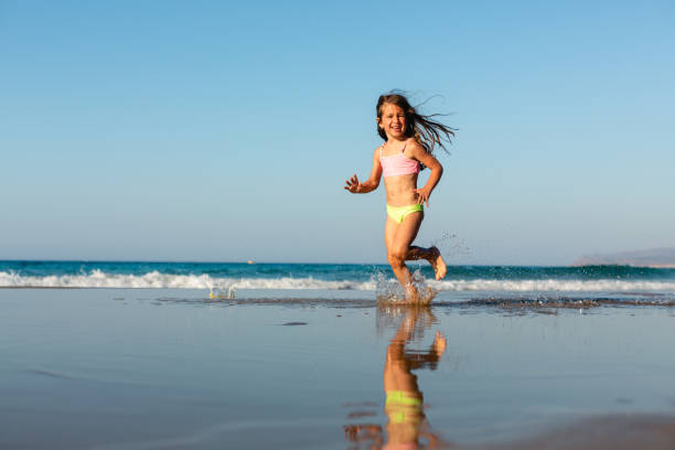 istock Playful girl running on the beach 1488208654