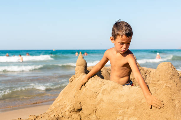 istock Boy making a sand castle on the beach 1488208686