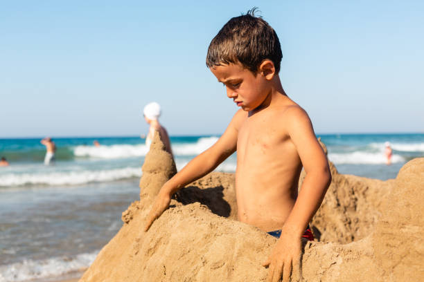 istock Boy making a sand castle on the beach 1488208729