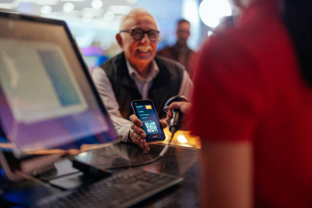 Senior man paying with mobile app in cinema. stock photo