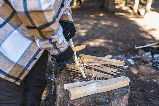 Cutting shavings with a bushcraft knife to get a fire