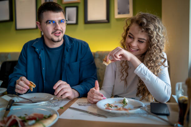 istock Happy smiling couple having fun while eating pizza 1488216707
