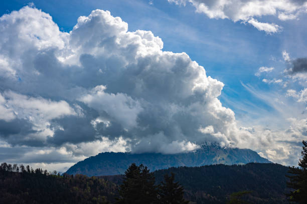 a storm cloud is forming over a mountain - switzerland forest storm summer imagens e fotografias de stock