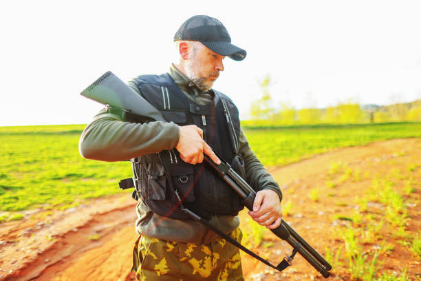 istock Hunter with a hunting gun in the field. Rifle hunter in Sunset. 1488219462