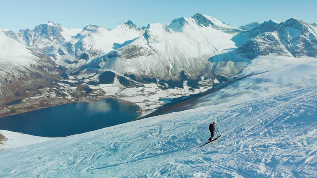 Ski touring man walk up mountain fjord in Norway