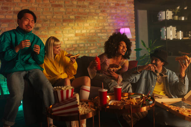 Cheerful friends eating takeout indoors.