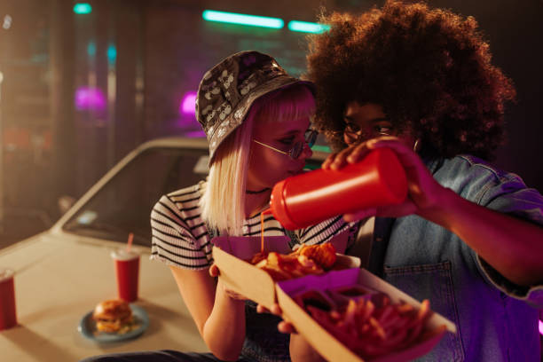 Girls enjoying fast food outdoors.