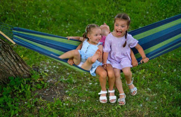 istock Comical humorous children laugh merrily while swinging on a hammock in park 1488228250