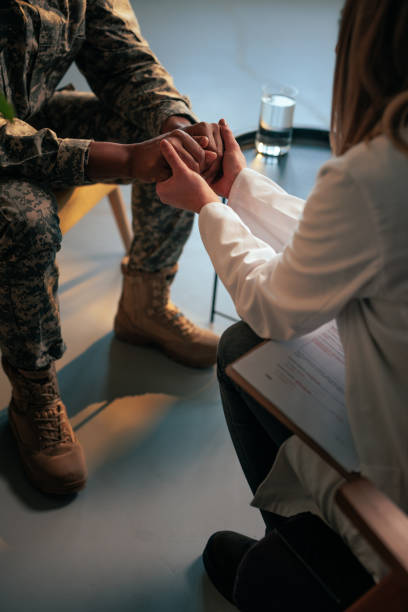 istock Soldier and psychologist holding hands in therapy. 1488230504