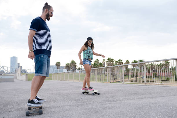 istock Hipster couple skating in park 1488231658