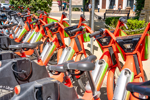 Sevilla, Spain - April 10, 2023: Rental bikes along Plaza de Espana on a sunny day.