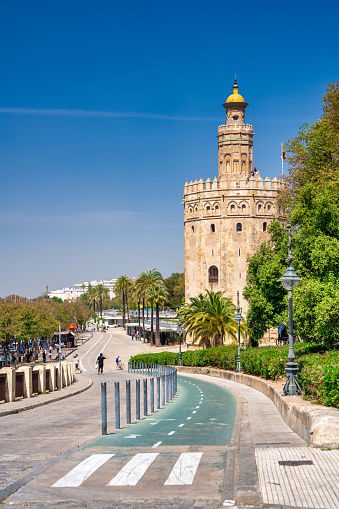 Sevilla, Spain - April 2023: Tourists along Torre del Oro, Golden Tower.