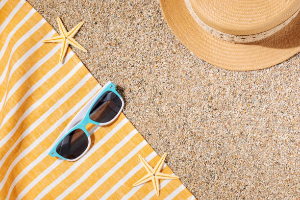 Straw hat and sunglasses on the beach sand