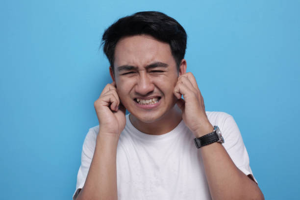 Young Man Close His Ears Dont Want to Hear Something Bad Portrait of young Asian man wearing casual white shirt closing his eyes and ears dont want or avoiding to hear bad news, stress under mental pressure concept man closing ears photos stock pictures, royalty-free photos & images