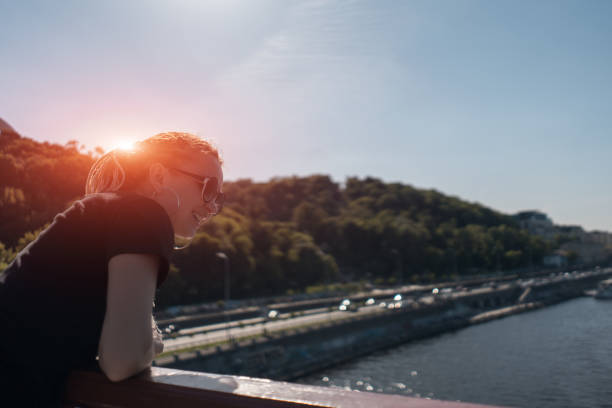 istock female tourist stay on bridge and look on river 1488241132