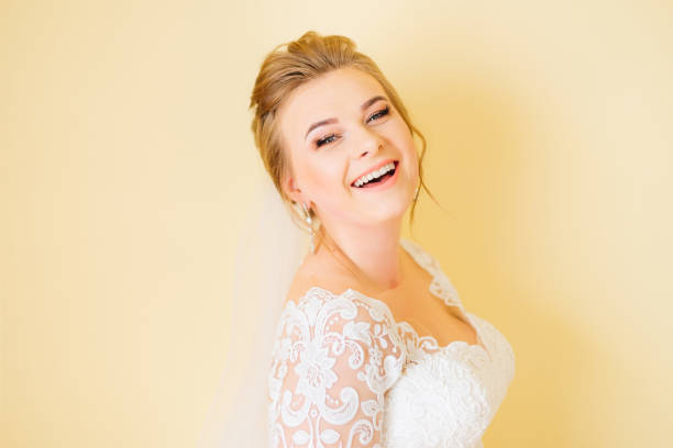 happy bride smiling and looking at camera. white wedding dress with a pattern.