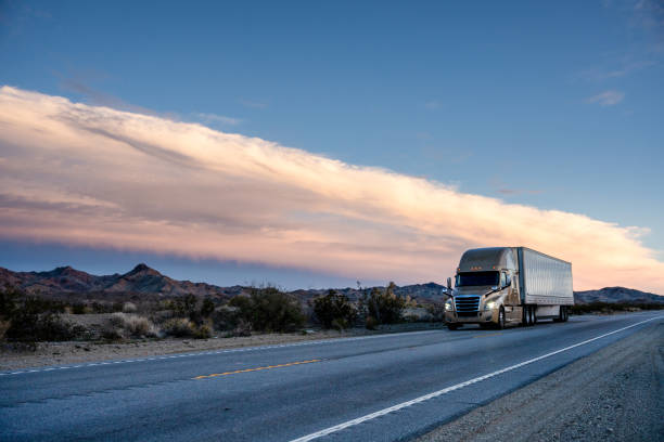 istock A Semi-Truck on a Two-Lane Highway with Beautiful Clouds at Sunset 1488244796