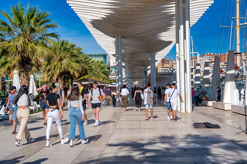 Malaga, Spain - April 14, 2023: Palmeral de las Sorpresas promenade at port in Malaga. Andalusia, Spain. Many people having fun in sunny day at this place..