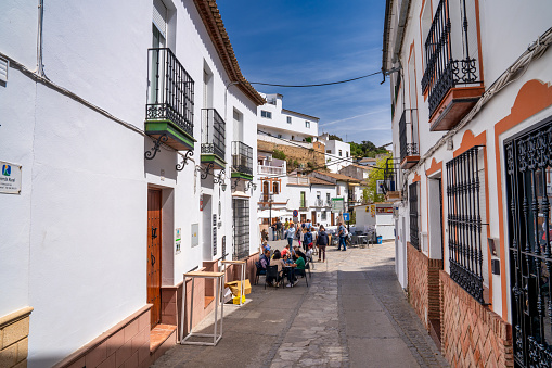 Setenil de las Bodegas, Spain - April 6, 2023: Typical Andalucian village with white houses and sreets with dwellings built into rock overhangs above Rio Trejo.