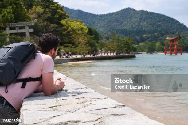 European Tourist Visit Itsukushima Jinja Otorii On The Sea Of Miyajima Japan Stock Photo - Download Image Now