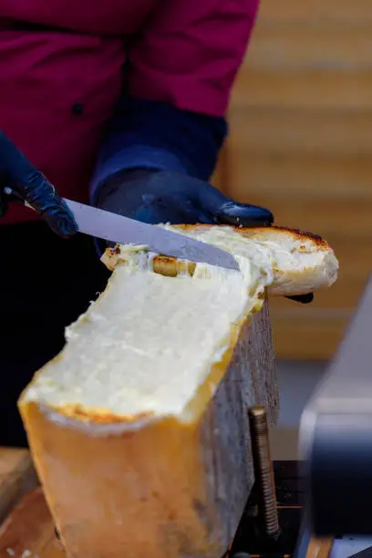 raclett cheese with hand and knife. Streetfood