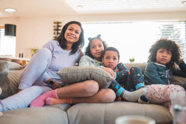 istock Single Mother Seated in Couch with Three Kids 1488250399
