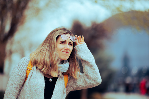 Unhappy person feeling confused and unable to see with her eyeglasses