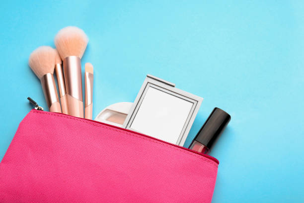 istock Cosmetic bag with pocket mirror and makeup products on light blue background, flat lay. Space for text 1488253935